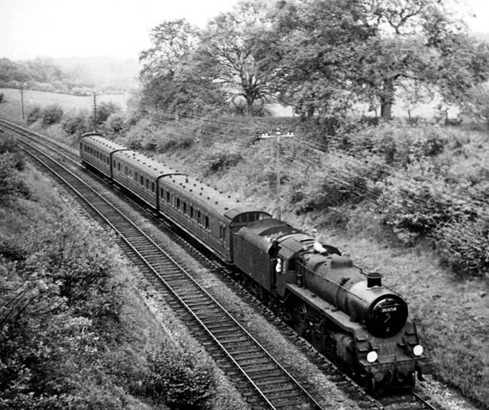 From White Down Lane overbridge, an unidentified Birdcage trio approaches Gomshall & Shere on the 5.31pm Redhill to Reading South train (1st June 1957) hauled by BR Standard 4MT no. 76054.
  Ben Brooksbank (Geograph/CC-by-SA)
