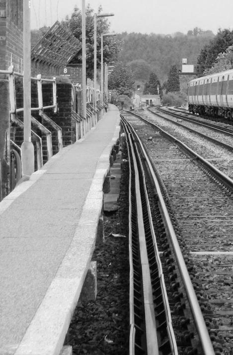 Walkway at Horsham’s Malthouse siding with protection boarded conductor adjacent (May 2008).
Note the modern anti-slip surface, white edging and steel handrails fitted to the rear.
www.EwhurstGreen.com 
