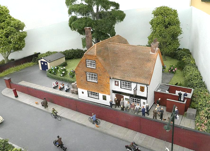 Customers mingle outside the Woolpack while some use the outside urinals as cats play on the coping stones.
One cyclist decides to push his cycle up the steep hill!
www.EwhurstGreen.com